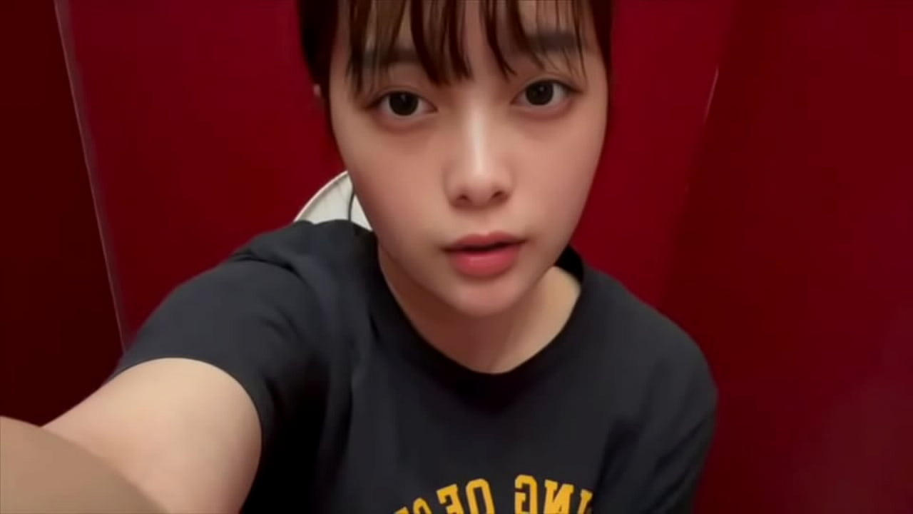 一名相貌平平的女大学生在卡拉 OK 的男厕所里自慰，闻着男人阴茎和小便的味道。